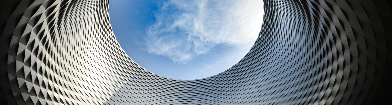 Looking up through an architectural lattice to open sky