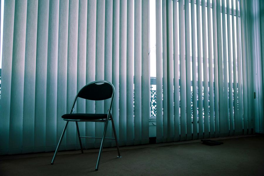 An empty chair beside a window