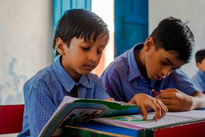 Two pupils sharing a textbook